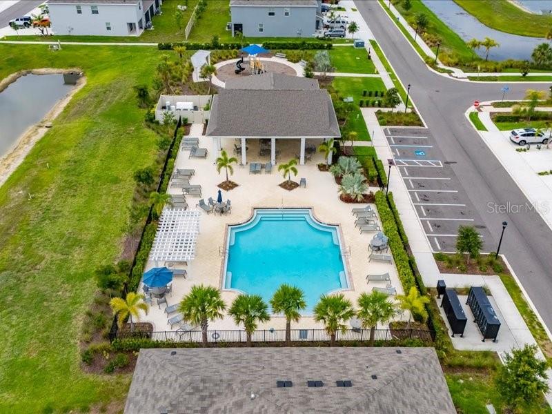 An aerial view shows a community swimming pool, covered patio, and playground next to parking — 416 MANGROVE SHADE CIRCLE, APOLLO BEACH, FL
