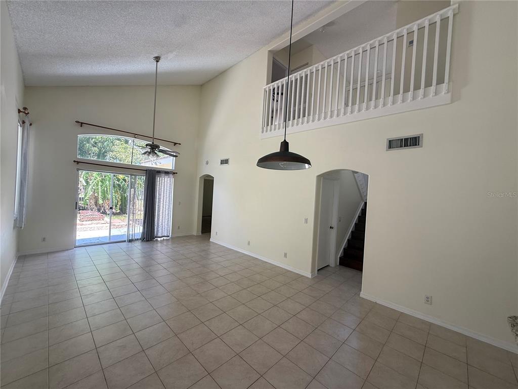 A spacious living area features tile flooring, a vaulted ceiling, and an open loft overlook — 6711 GREEN ISLAND CIRCLE, LAKE WORTH, FL