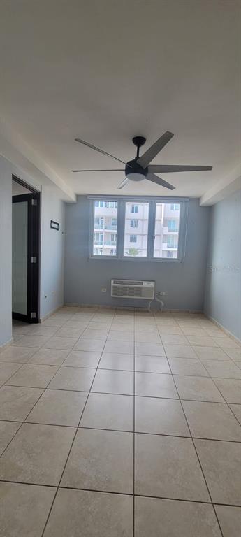 An empty room with light tile flooring, a ceiling fan, and a window air conditioner — 1400 JOSE DE DIEGO AVE COND PALACIOS DEL ESCORIAL UNIT 9-51, CAROLINA, PR