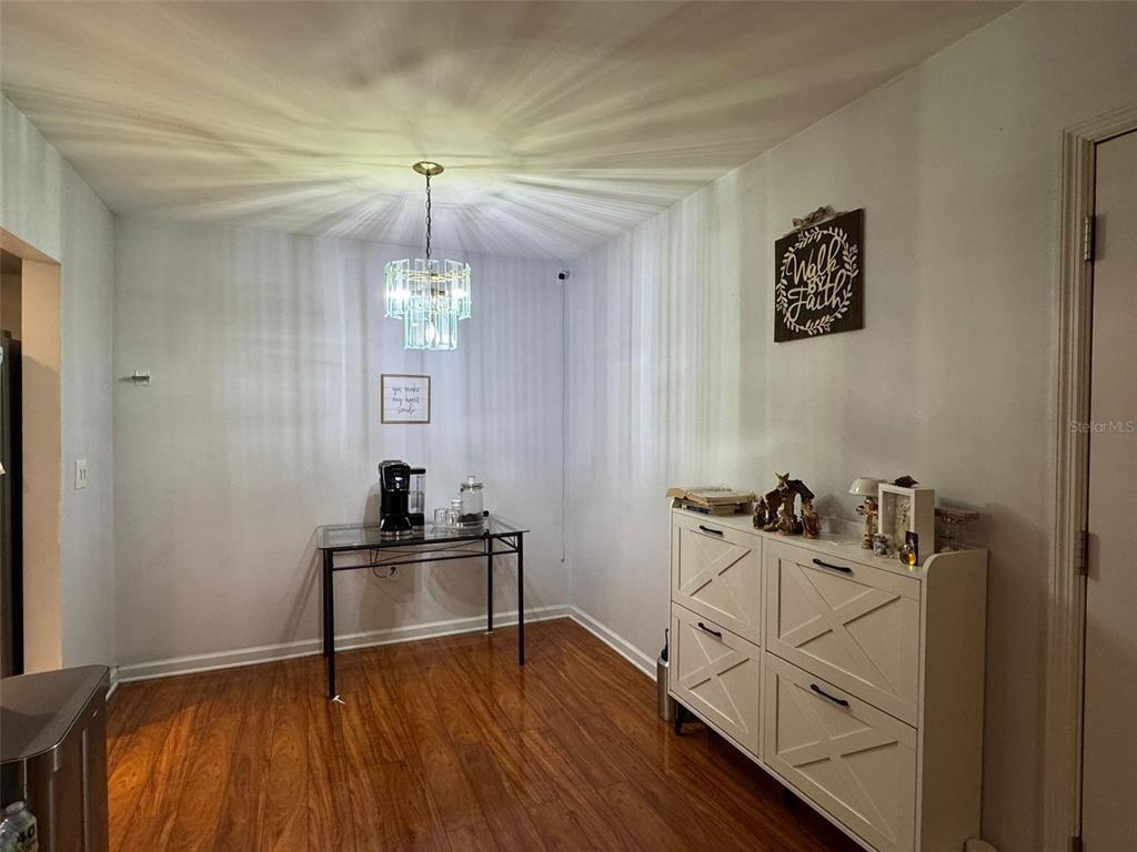 A dining area features wood flooring, a glass console table, and a white storage cabinet — 912 LAKE DESTINY ROAD UNIT G, ALTAMONTE SPRINGS, FL