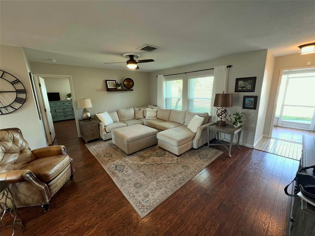 A living room features a sectional sofa, an area rug, and a leather armchair — 9359 CASA GRANDE AVENUE, ENGLEWOOD, FL