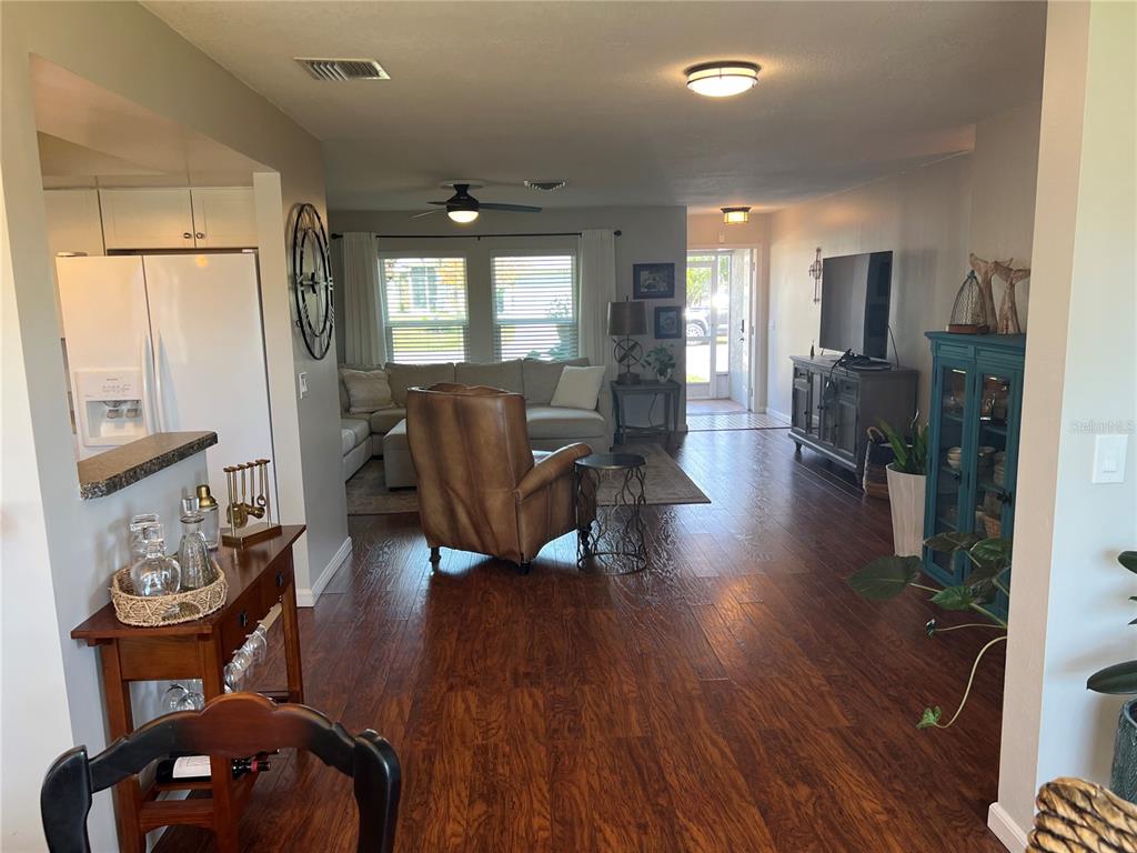 A living room features hardwood floors, a leather armchair, a sectional sofa, and a television — 9359 CASA GRANDE AVENUE, ENGLEWOOD, FL