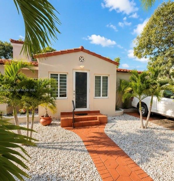 A single-story stucco house with a tiled walkway, palm trees, and a white vehicle parked nearby — 741 NE 81st St, Miami FL 33138, MIAMI, FL