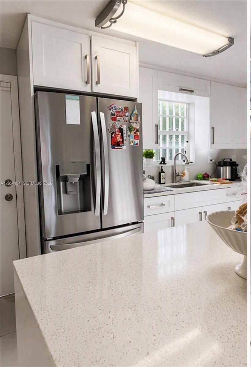 A kitchen featuring white cabinets, stainless steel appliances, and a light-colored speckled quartz countertop — 741 NE 81st St, Miami FL 33138, MIAMI, FL