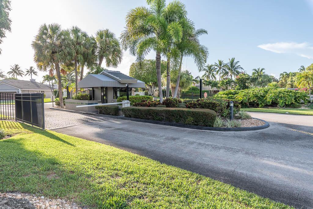 A gated entrance features a guardhouse, palm trees, and a paved driveway — 251 NW 69th Street, Boca Raton FL 33487, BOCA RATON, FL