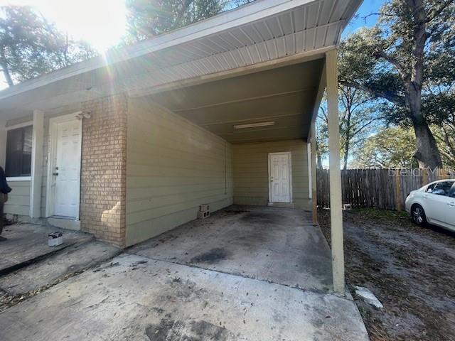 A concrete driveway leads to a covered carport attached to a house with two doors — 2523 ALEXA COURT, WINTER PARK, FL