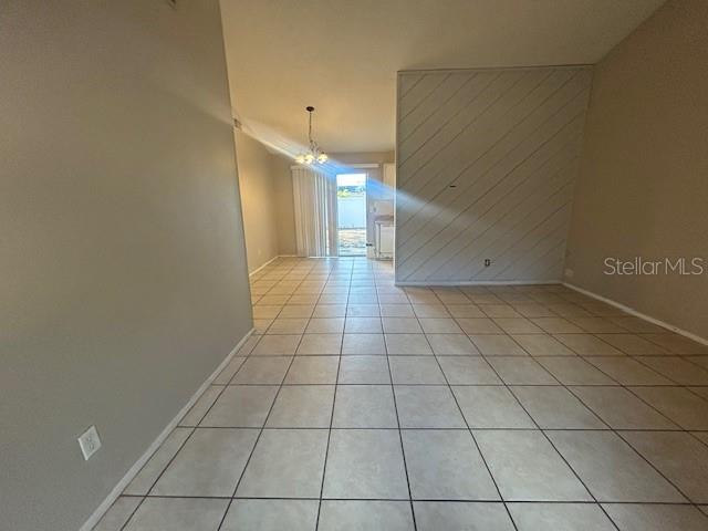 A tiled living area features a diagonal wood-paneled wall and a sliding glass door — 2523 ALEXA COURT, WINTER PARK, FL