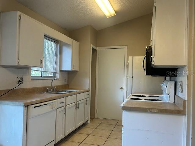 A kitchen features white cabinets, a dishwasher, a stove, and a window over the sink — 2523 ALEXA COURT, WINTER PARK, FL