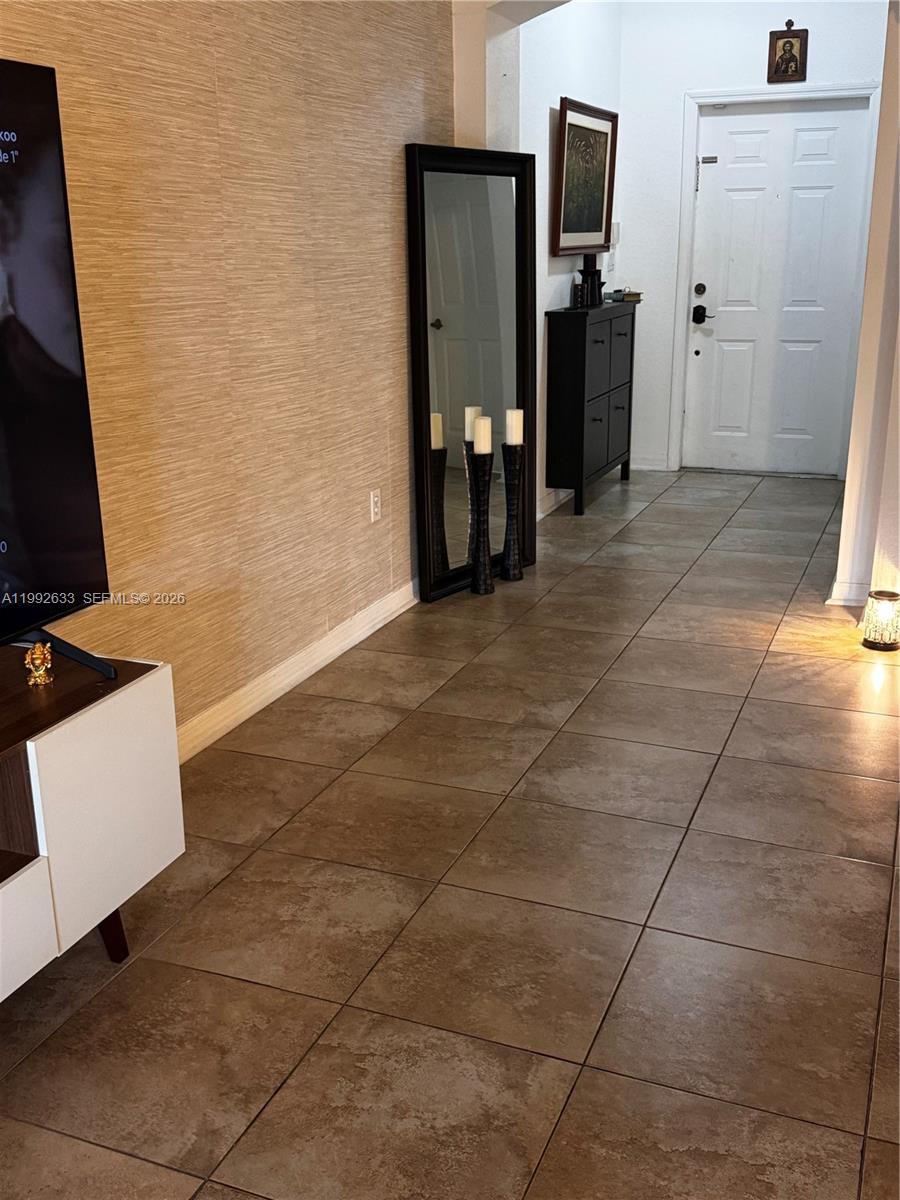 A tiled entryway features a full-length mirror, a dark cabinet, and a white front door — 10723 NW 85th Ter # 38, Doral FL 33178, DORAL, FL