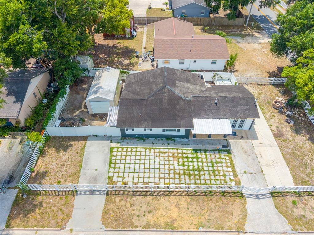An aerial view shows a house with a detached garage and a paved front yard — 1230 E 1ST AVENUE, MOUNT DORA, FL