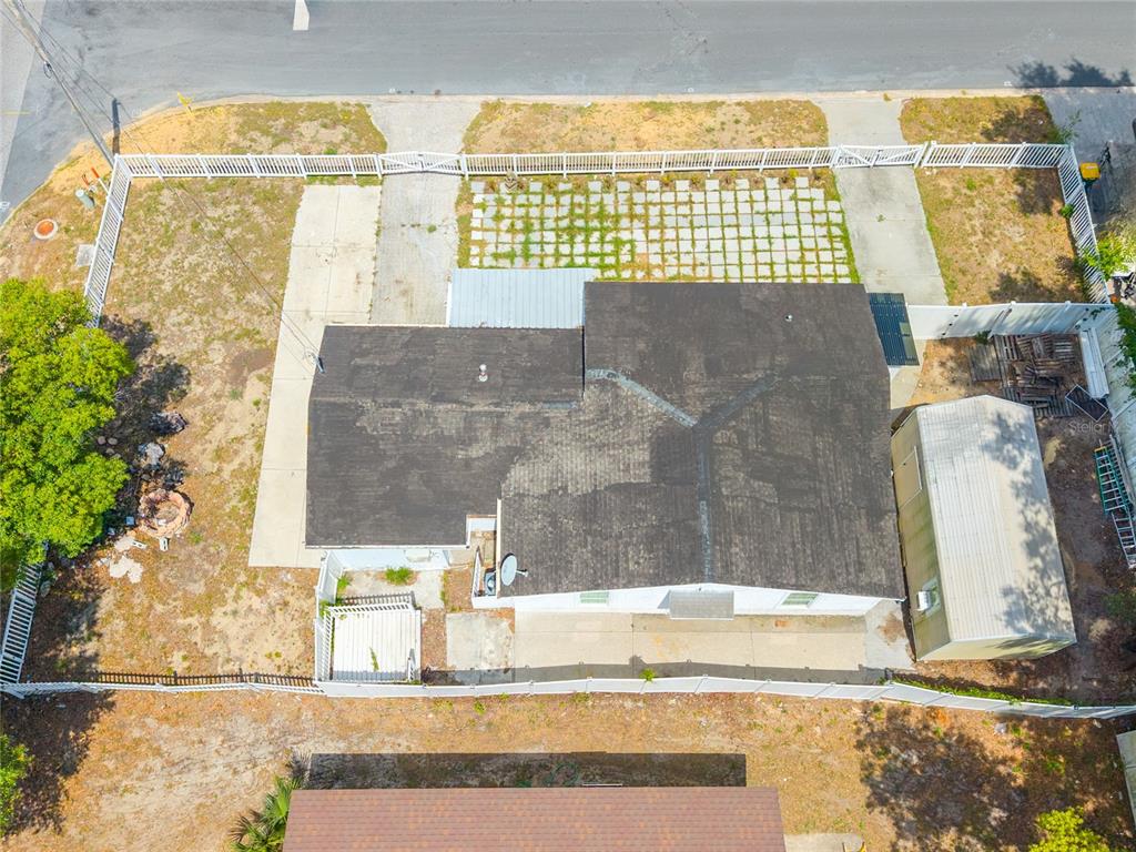 An aerial view shows a house with a dark roof, a shed, and a fenced yard — 1230 E 1ST AVENUE, MOUNT DORA, FL