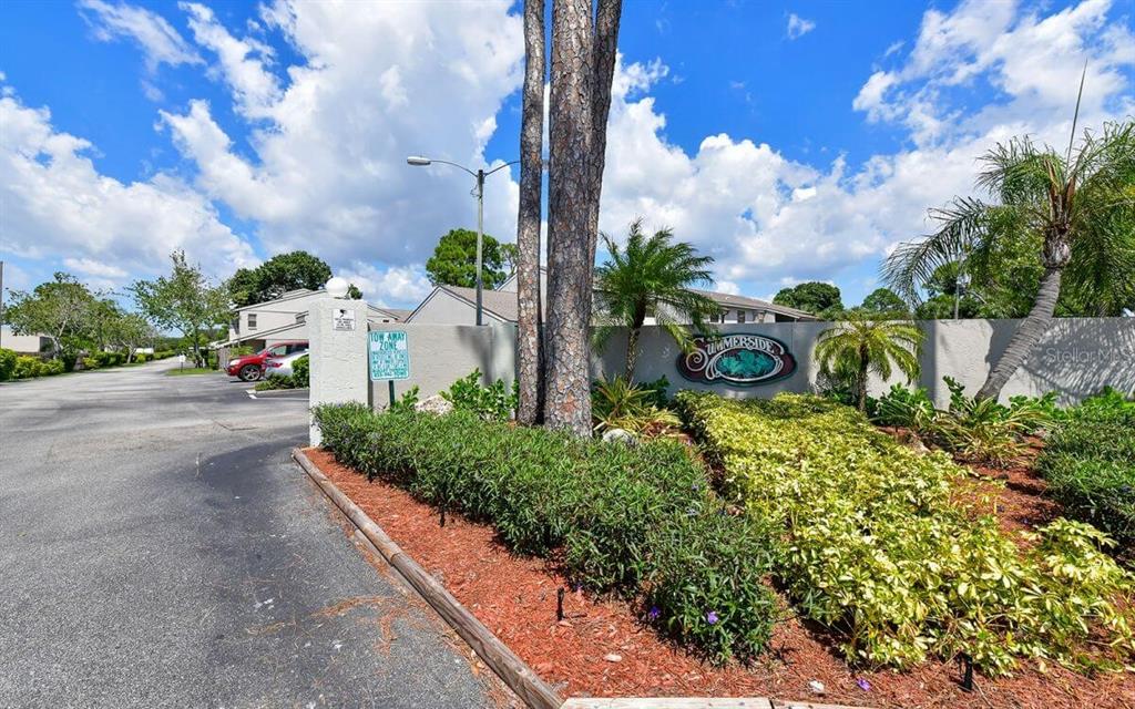 An exterior view of the Summerside community entrance sign with landscaping and a parking area — 5647 SUMMER SIDE LANE UNIT 41A, SARASOTA, FL