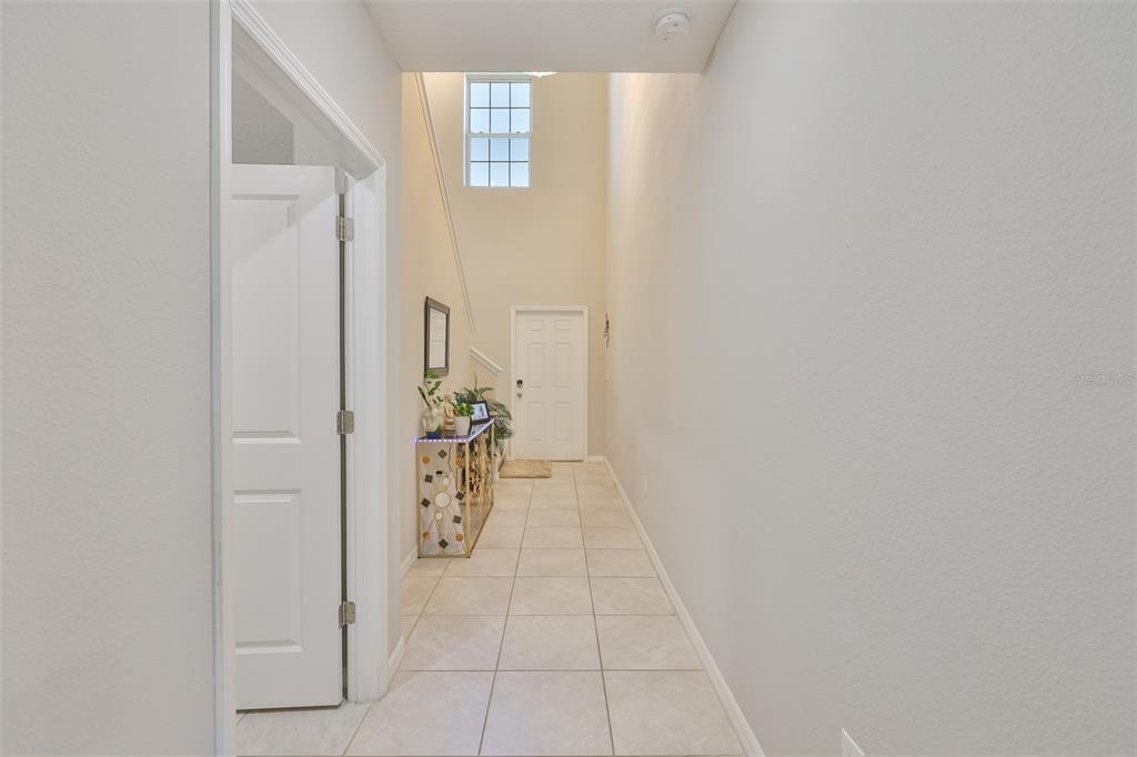 A tiled entryway leads to a white front door under a high, vaulted ceiling — 10335 SHADY PRESERVE DRIVE, RIVERVIEW, FL