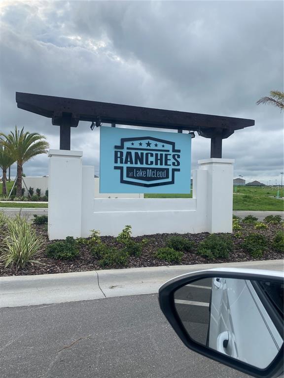 A sign for Ranches at Lake McLeod stands between two white pillars under a pergola — 2125 LASSO LOOP, EAGLE LAKE, FL