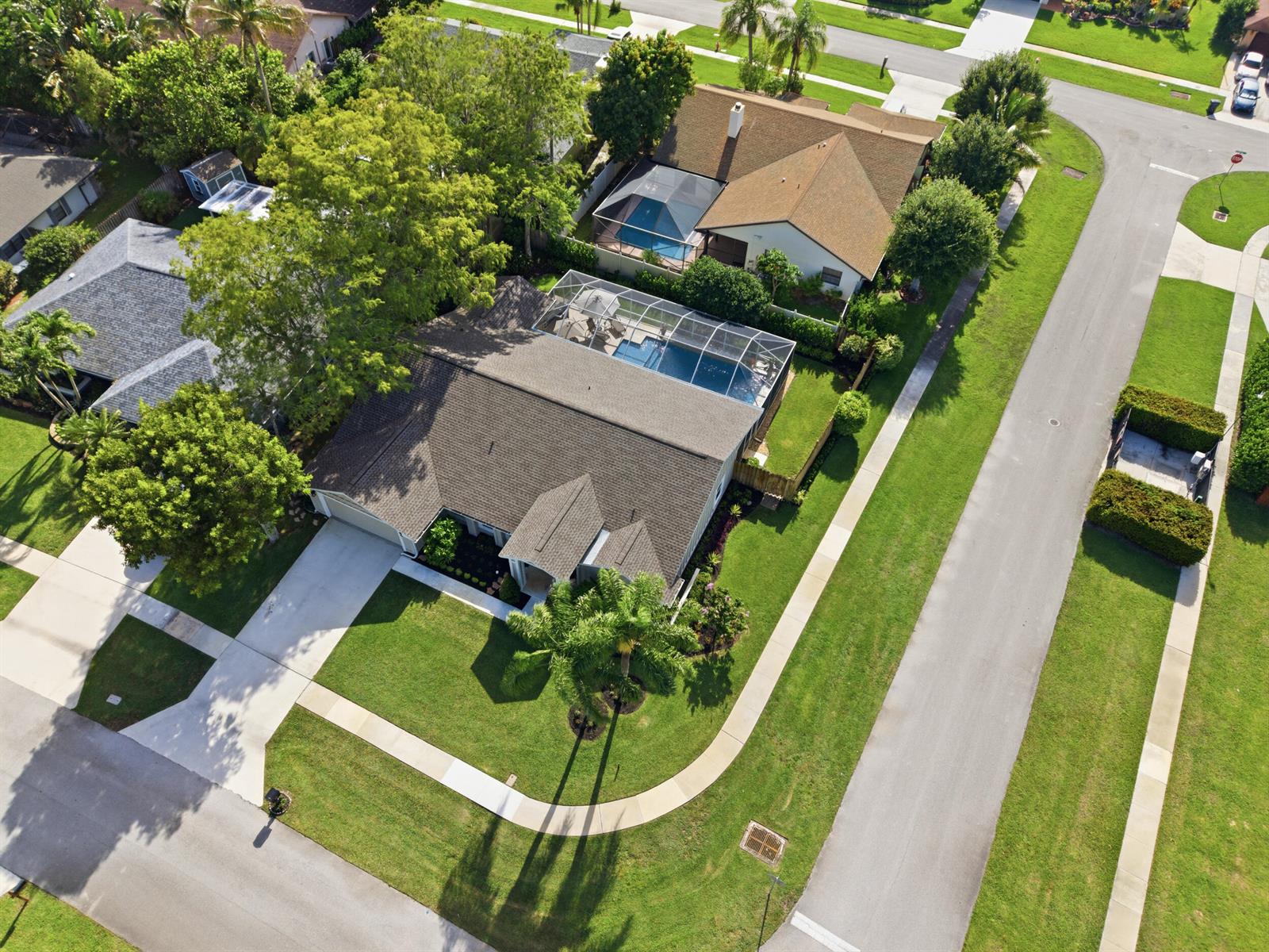 An aerial view shows a suburban house with a screened-in pool and a corner lot — 805 Daffodil Drive, Wellington FL 33414, WELLINGTON, FL