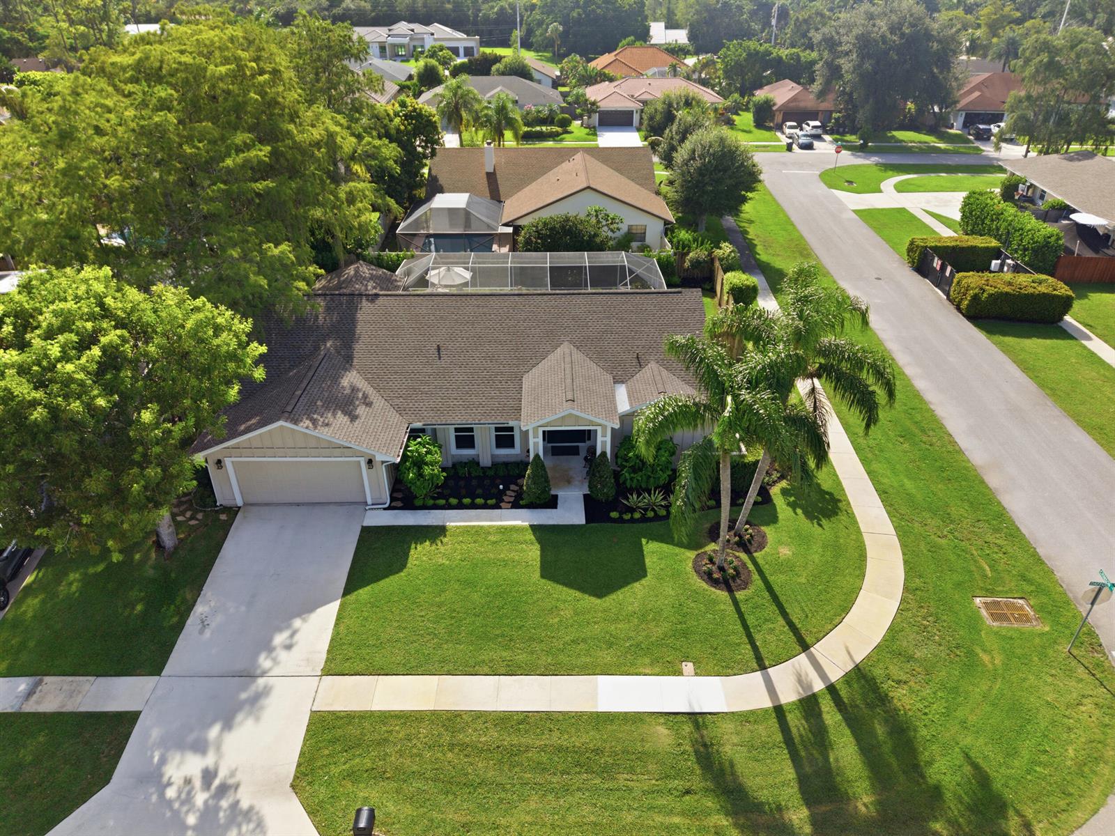 An aerial view of a single-story house with a garage, pool cage, and palm tree — 805 Daffodil Drive, Wellington FL 33414, WELLINGTON, FL