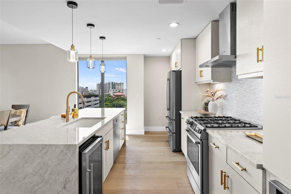 A modern kitchen features a marble island, stainless steel appliances, and a view of city buildings — 199 DALI BOULEVARD UNIT 1001, ST PETERSBURG, FL