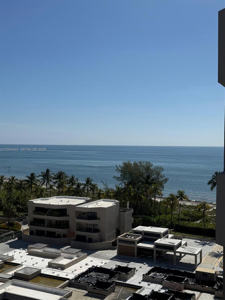 An elevated view shows a beach, palm trees, and modern buildings under a clear sky — 201 Crandon Blvd # 932, Key Biscayne FL 33149, KEY BISCAYNE, FL