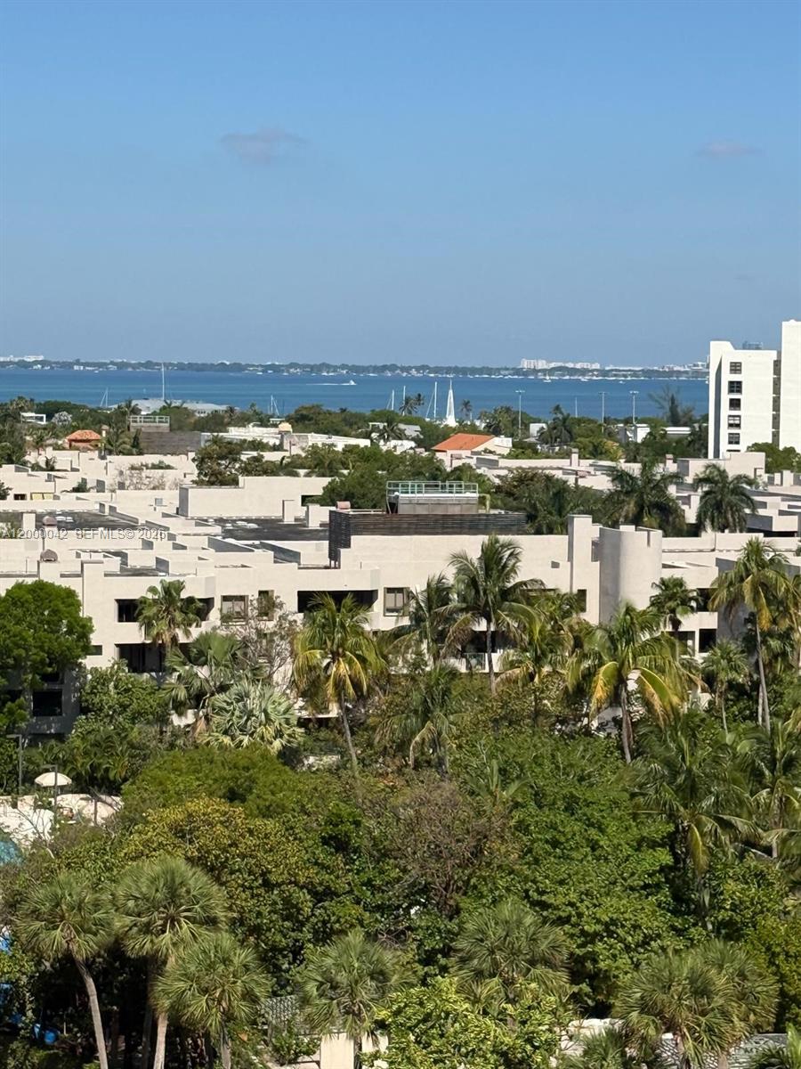 An elevated view shows a residential complex with palm trees overlooking a distant bay — 201 Crandon Blvd # 932, Key Biscayne FL 33149, KEY BISCAYNE, FL