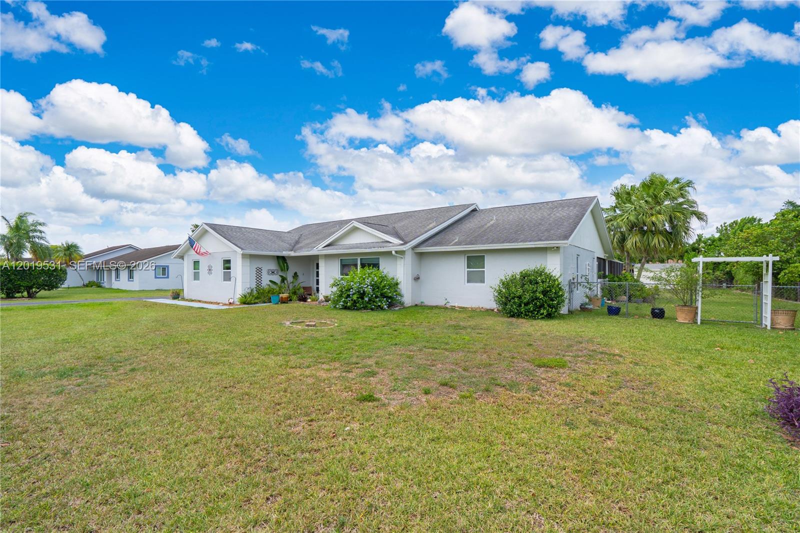A single-story house with a light gray exterior, a front lawn, and a gabled roof — 1501 NW 20th St, Homestead FL 33030, HOMESTEAD, FL