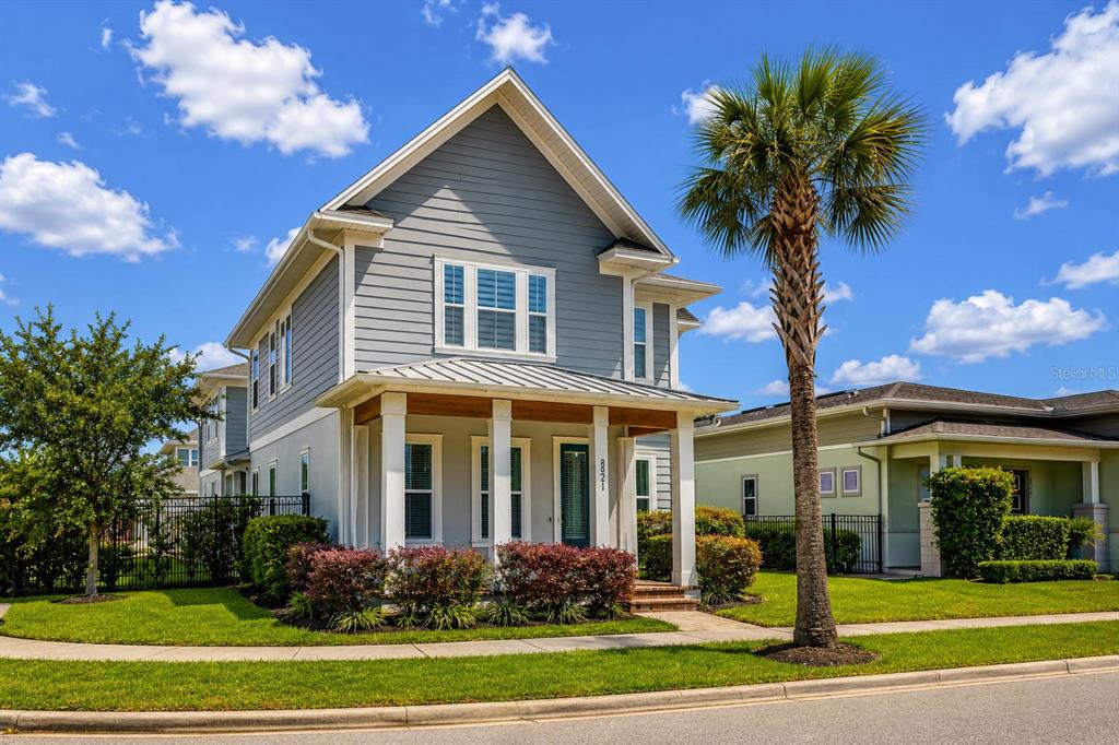 A two-story house with gray siding, a front porch, and a palm tree in front — 8521 DUBOCHET STREET, ORLANDO, FL