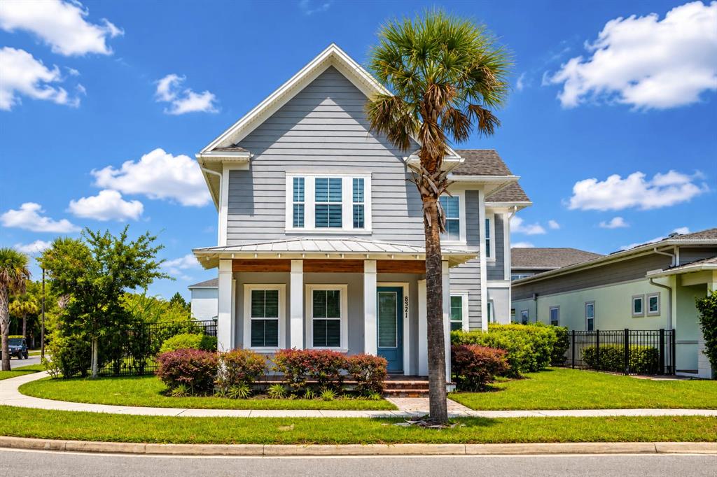 A two-story gray house with a front porch, a palm tree, and a green lawn — 8521 DUBOCHET STREET, ORLANDO, FL