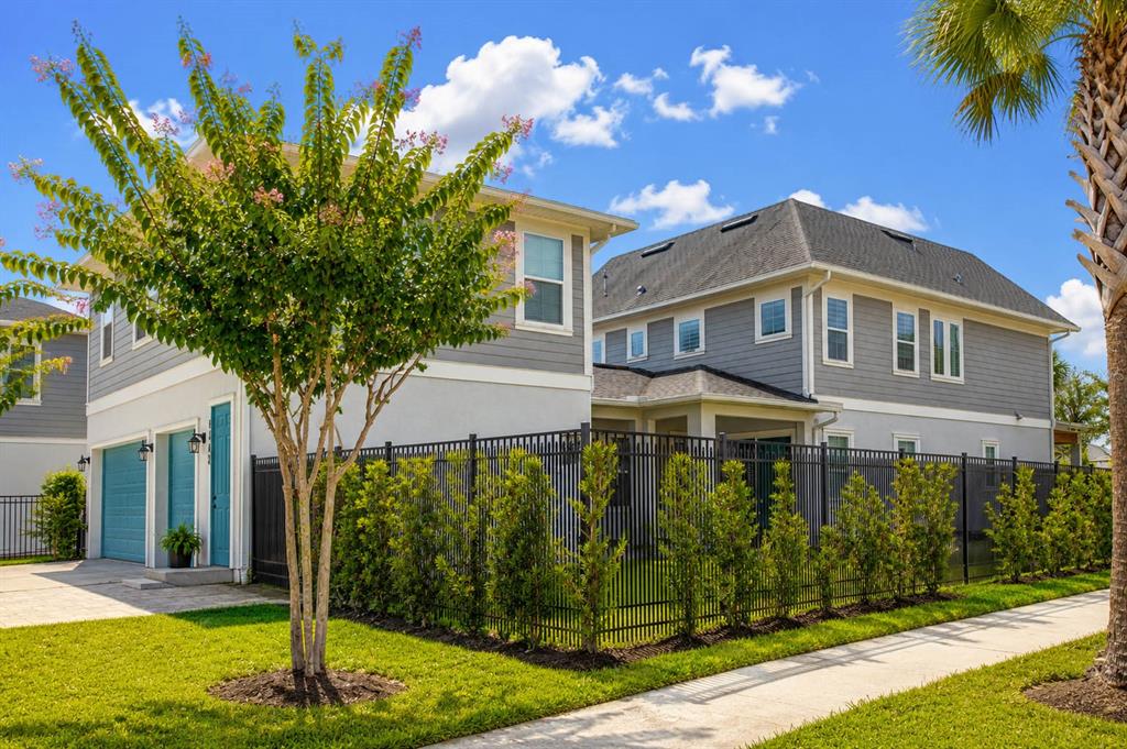 A two-story house with gray siding, a black metal fence, and a manicured lawn — 8521 DUBOCHET STREET, ORLANDO, FL
