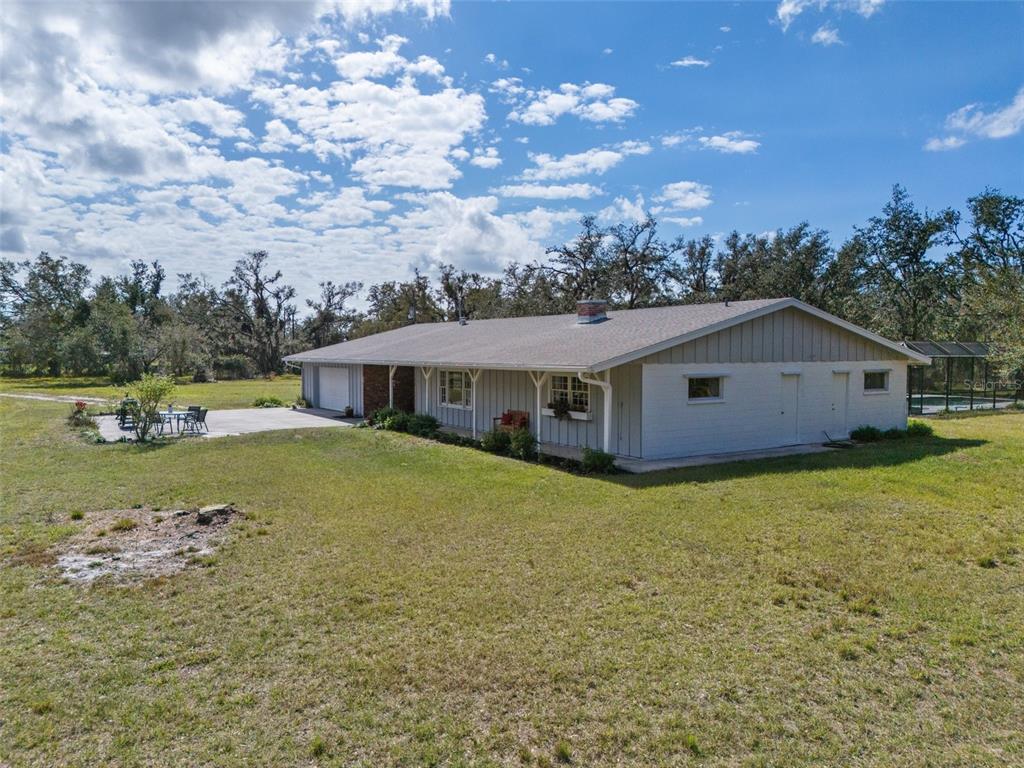 A single-story house with light gray siding and a concrete patio sits on a lawn — 1510 LENA LANE, SARASOTA, FL