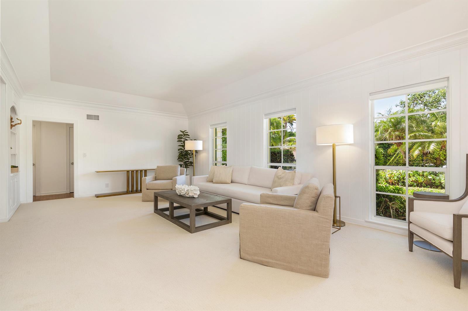 A bright living room features white walls, a beige carpet, a sofa, and armchairs — 241 Via Linda, Palm Beach FL 33480, PALM BEACH, FL