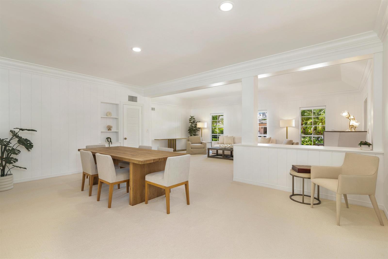 A dining area with a wooden table and chairs opens into a carpeted living room — 241 Via Linda, Palm Beach FL 33480, PALM BEACH, FL