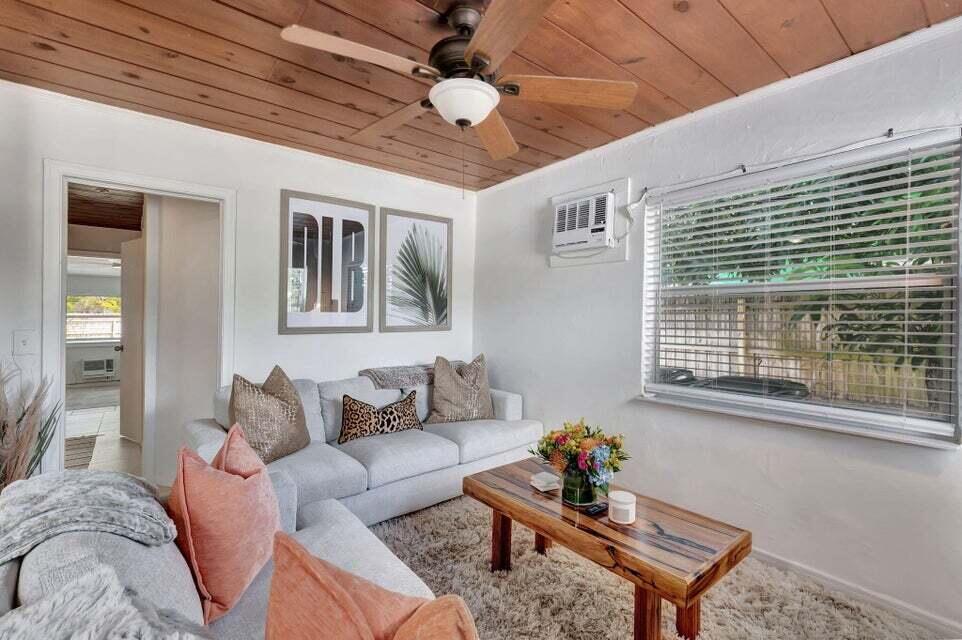 A living room features a wood-paneled ceiling, a ceiling fan, a sofa, and a coffee table — 329 SE 3rd Avenue, Delray Beach FL 33483, DELRAY BEACH, FL