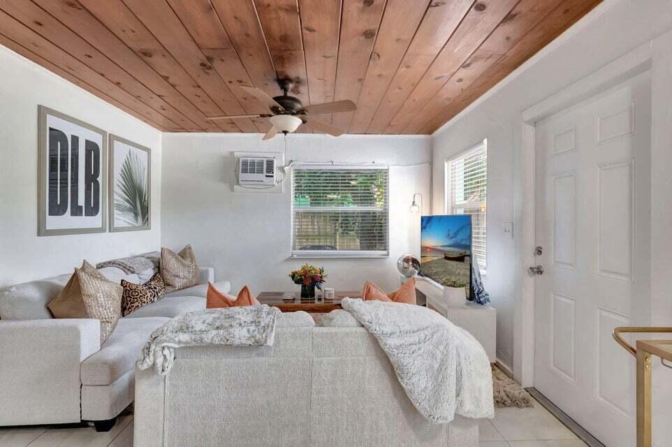 A living room features a wood-paneled ceiling, a ceiling fan, and white sofas — 329 SE 3rd Avenue, Delray Beach FL 33483, DELRAY BEACH, FL