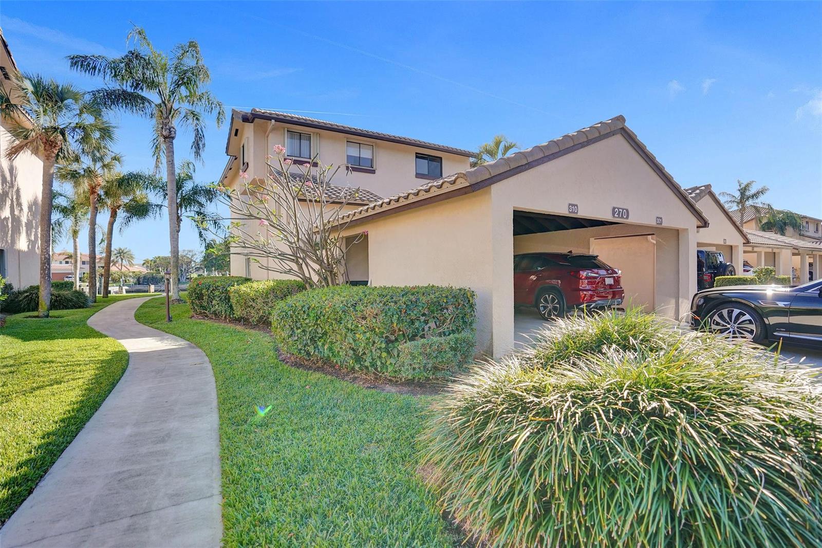 A two-story tan residential building with a carport and a curved sidewalk in front — 270 Captains Walk # 310, Delray Beach FL 33483, DELRAY BEACH, FL