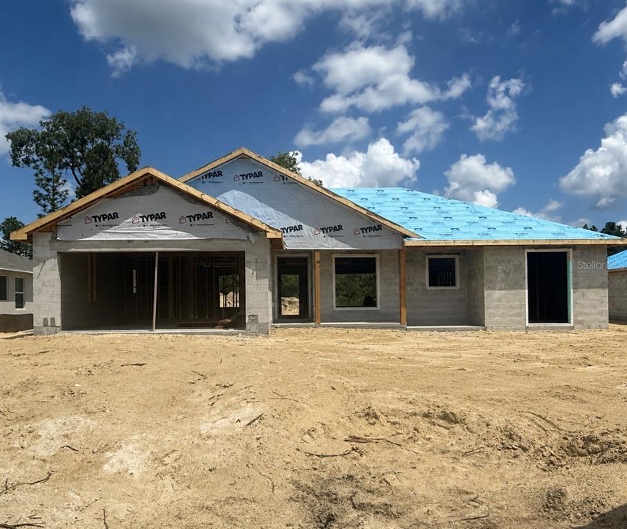 A digital rendering of a single-story house with a gray exterior and a two-car garage — 699 W HALLAM, DUNNELLON, FL