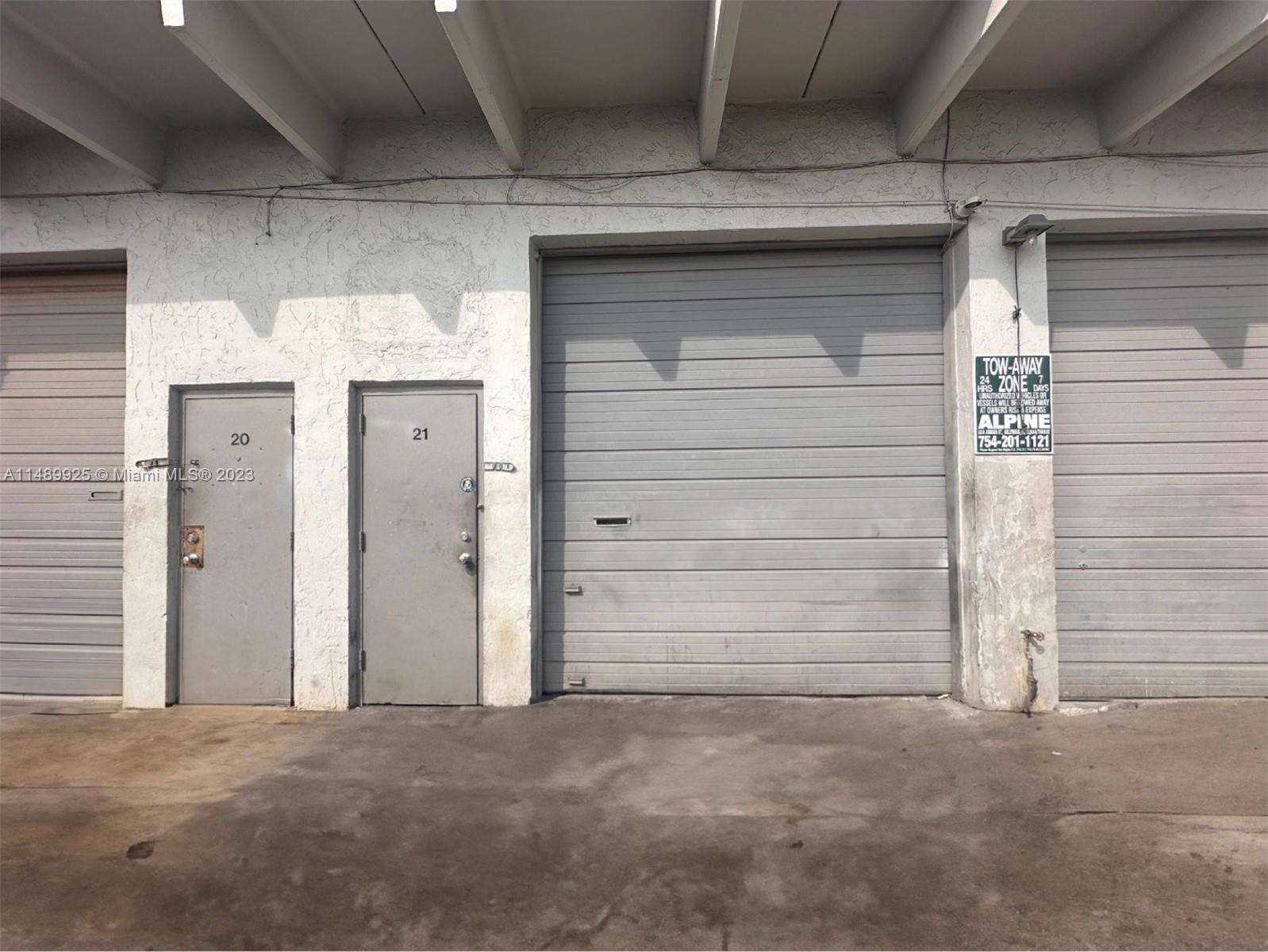 The exterior of a commercial building features two metal doors and a large roll-up door — 5801-5807 Dawson St, Hollywood FL 33023, HOLLYWOOD, FL