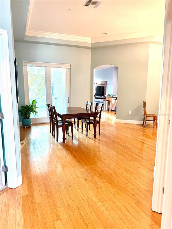 A dining area with hardwood floors, a wooden table, and sliding glass doors to the outside — 2008 N POINTE ALEXIS DRIVE, TARPON SPRINGS, FL