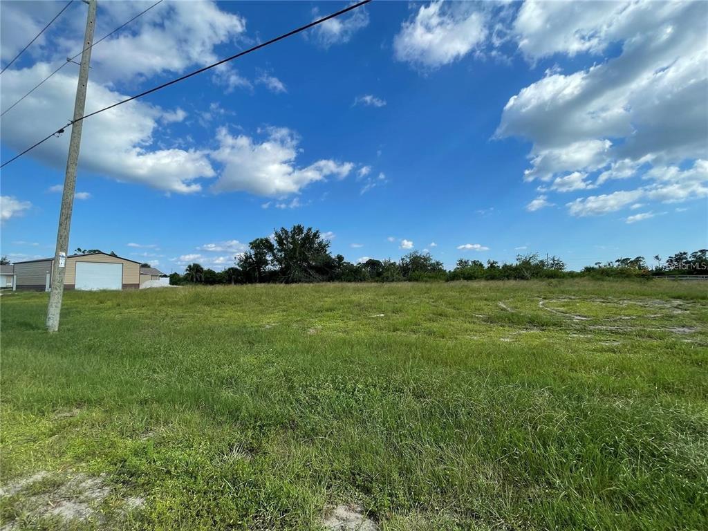A grassy, vacant lot under a blue sky with scattered clouds — 12743 FORESMAN BLVD, PORT CHARLOTTE, FL