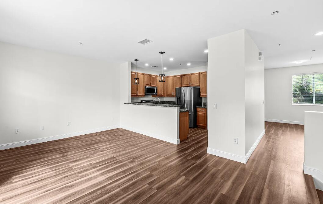 An open-concept kitchen with wood cabinets and stainless steel appliances overlooks a living area — 536 N West 39th Circle, Boca Raton FL 33431, BOCA RATON, FL