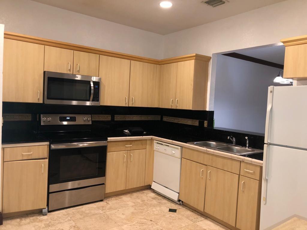 A kitchen with light wood cabinets, black countertops, stainless steel appliances, and tile flooring — 5449 NW 90th Avenue, Sunrise FL 33351, SUNRISE, FL
