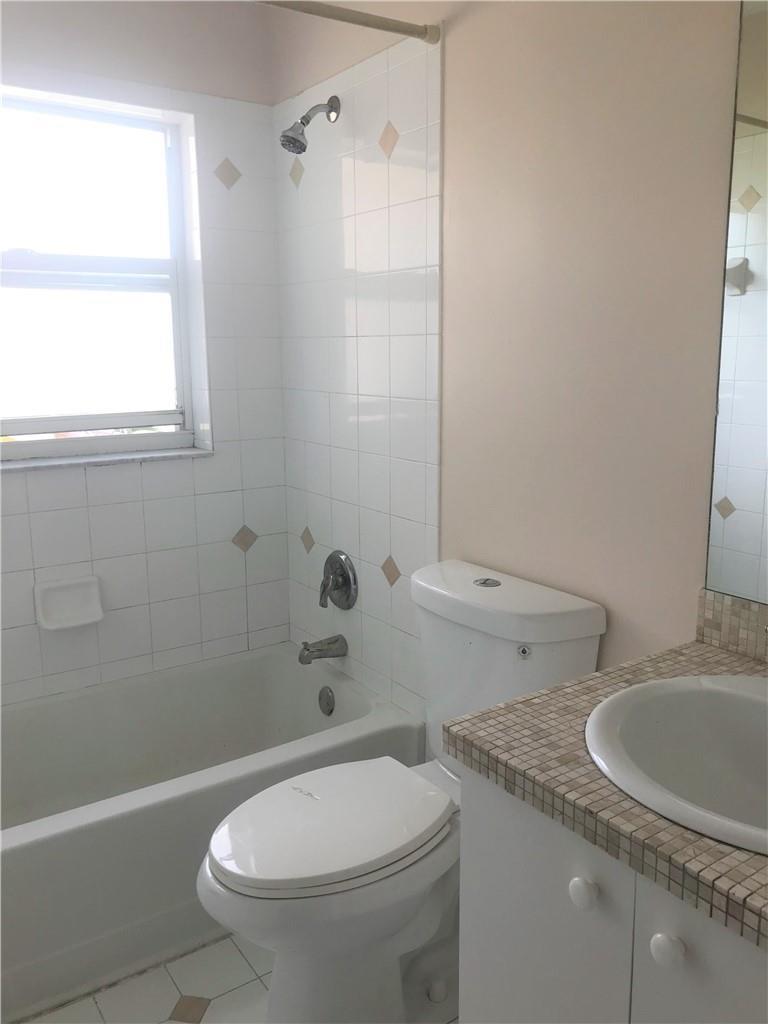A bathroom featuring a white bathtub, a toilet, and a vanity with a tiled countertop — 5449 NW 90th Avenue, Sunrise FL 33351, SUNRISE, FL