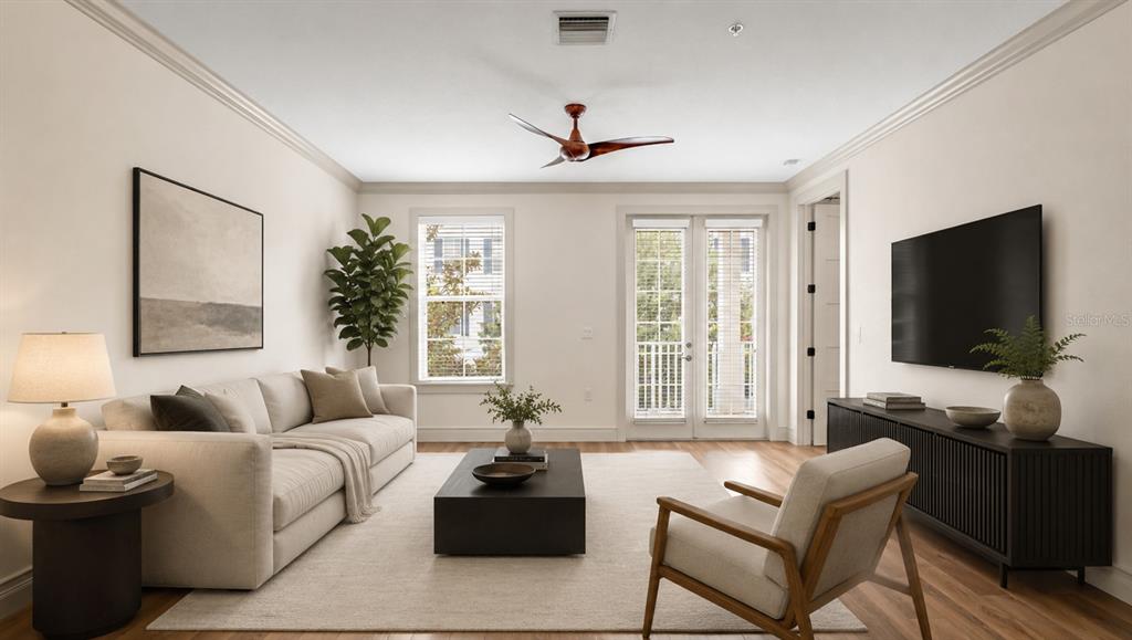 A living room features a beige sofa, a dark coffee table, and a wall-mounted television — 4286 ANISSA AVENUE UNIT 10-202, ORLANDO, FL
