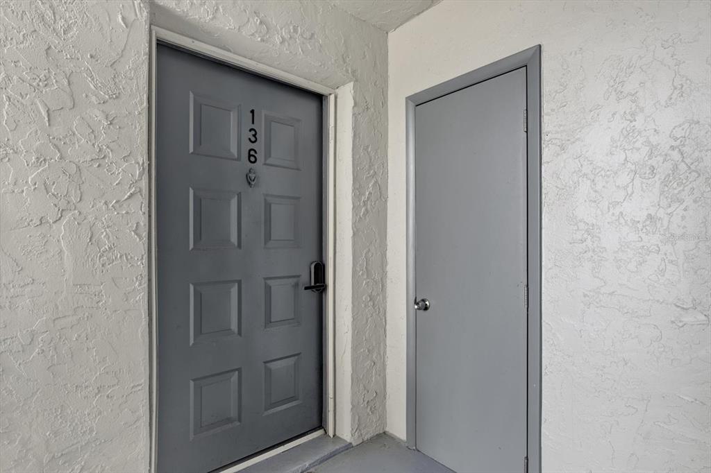 A gray front door with the number 136 and an adjacent utility closet door — 10800 US HIGHWAY 19 N UNIT 136, PINELLAS PARK, FL