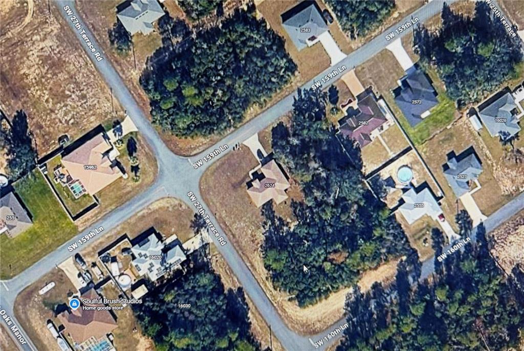 An aerial view shows a residential neighborhood with houses, wooded areas, and intersecting streets — LOT 10 SW 27TH TERRACE ROAD, OCALA, FL