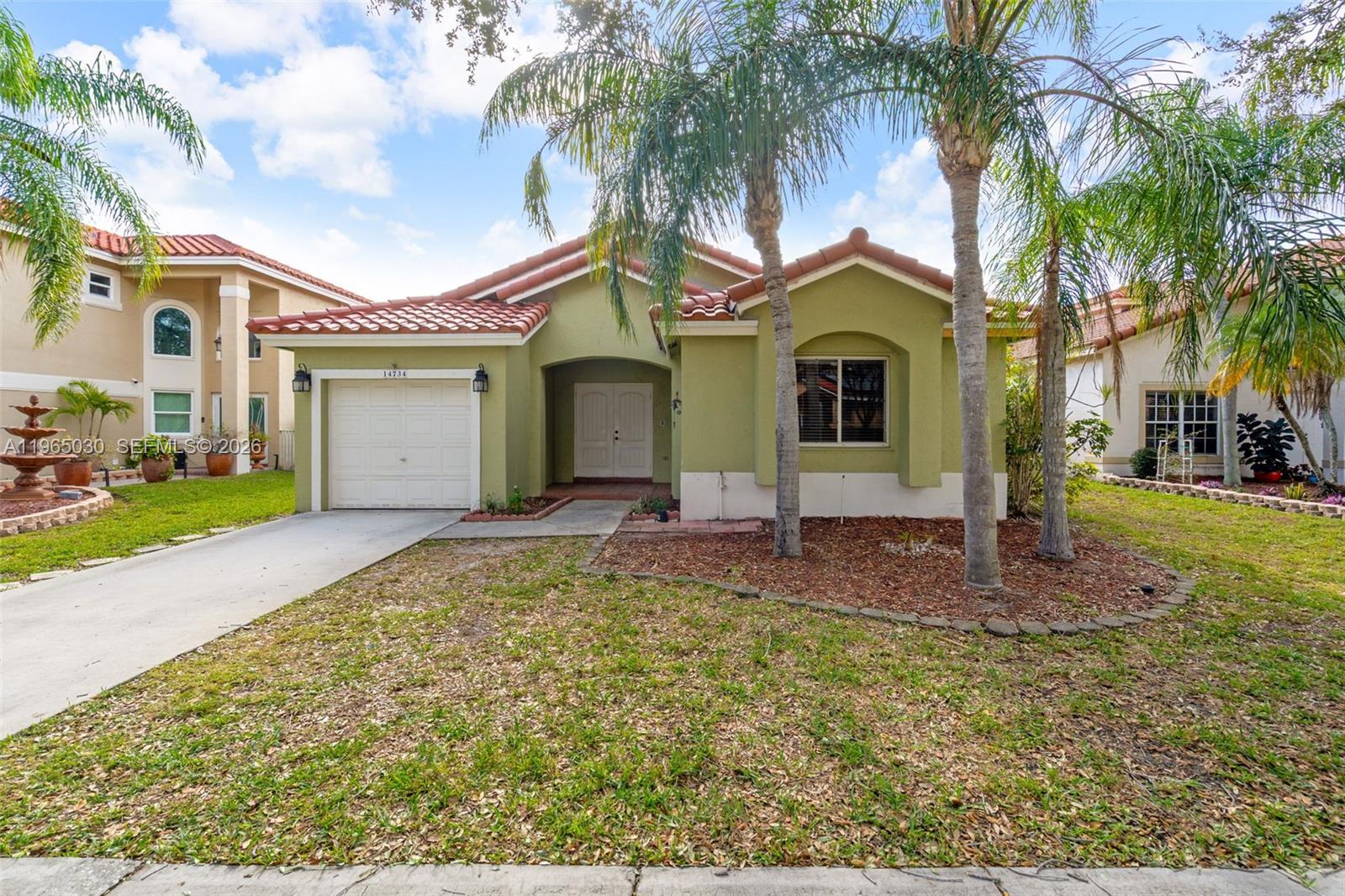 A single-story house with a green exterior, red tile roof, and a one-car garage — 14734 Via Tivoli Ct, Davie FL 33325, DAVIE, FL