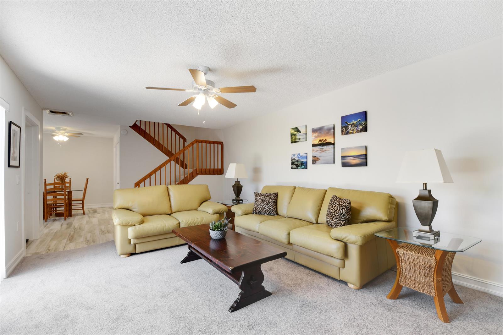 A living room features light-colored leather sofas, a wooden coffee table, and a staircase — 1603 16th Court, Jupiter FL 33477, JUPITER, FL