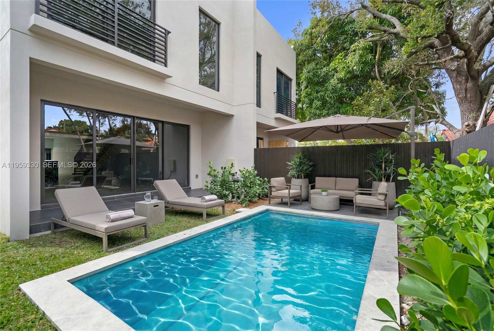 A modern two-story house features a backyard with a swimming pool and patio furniture — 1431 SW 20th St, Miami FL 33145, MIAMI, FL