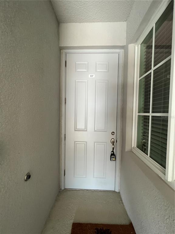 A white exterior door labeled 537 sits in a recessed entryway next to a window — 14051 HERITAGE LANDING BOULEVARD UNIT 537, PUNTA GORDA, FL