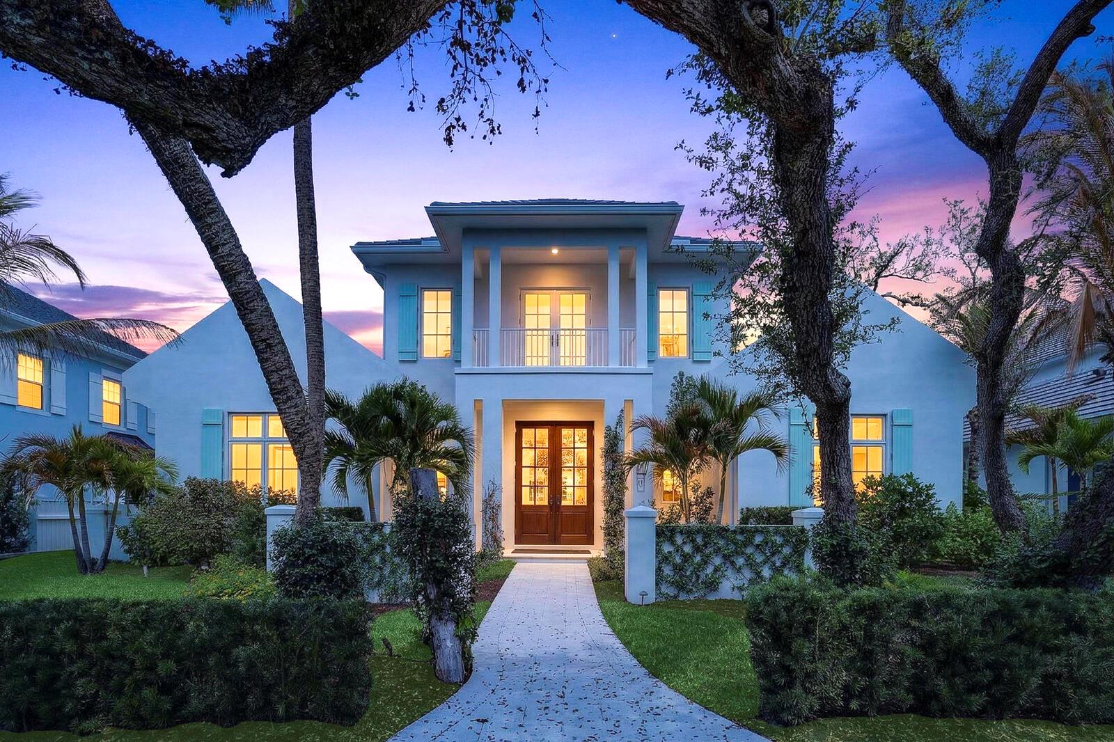 A two-story house with a white exterior, double front doors, and a paved walkway — VERO BEACH, FL