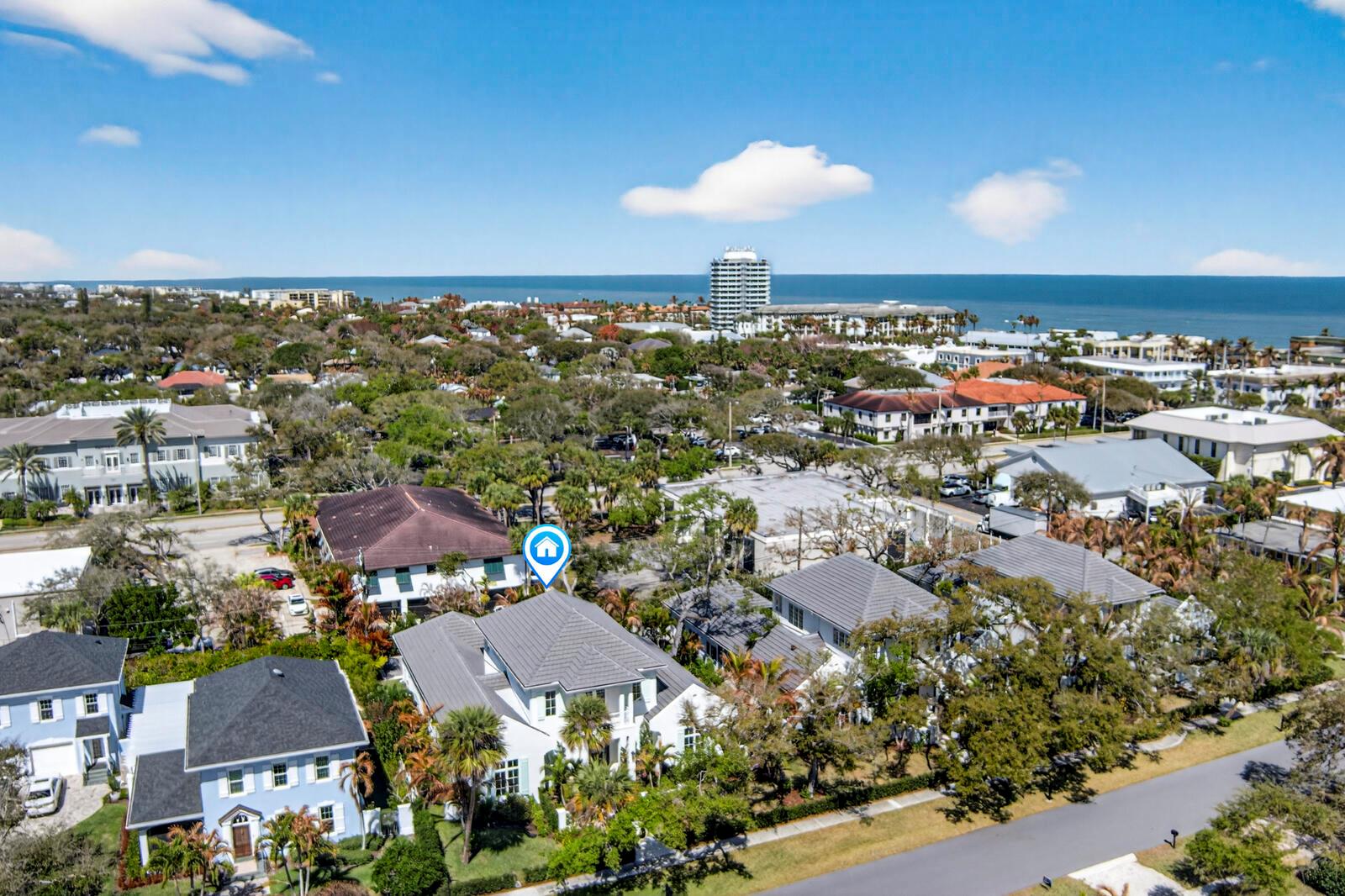 An aerial view shows a white two-story house with a gray roof in a neighborhood — VERO BEACH, FL