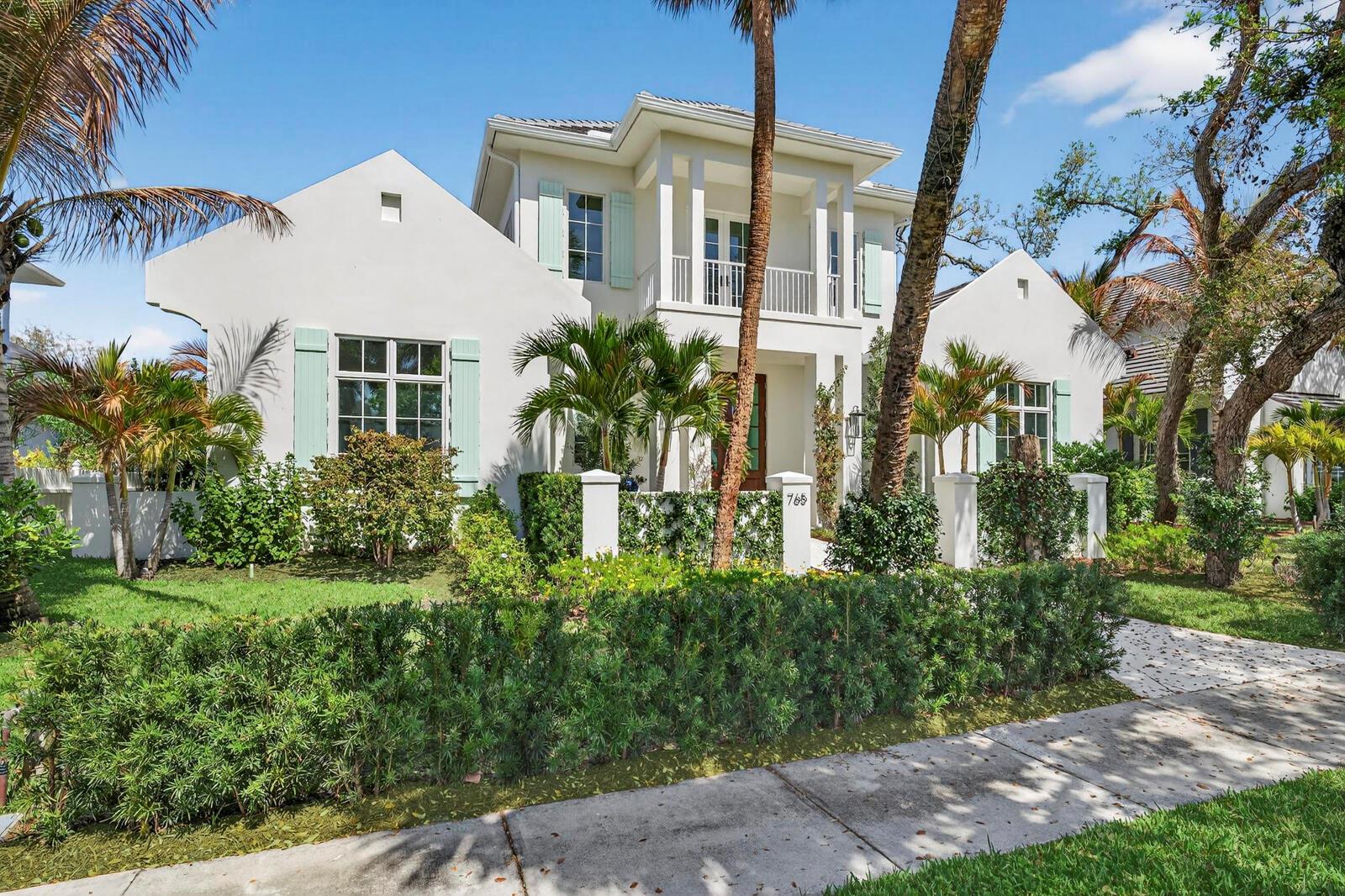 A two-story white house with light green shutters, a balcony, and palm trees in front — VERO BEACH, FL